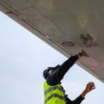 Hoof Maintenance - man in green safety vest standing under white structure