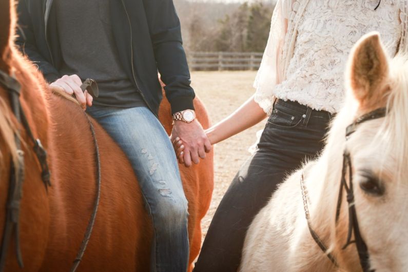 Healing Horse - man and woman riding horses while holding hands during day