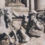 Mythical Horse - a statue of a man riding a horse next to a statue of a horse