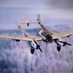 Historical Gear - a fighter jet flying through the air over a forest