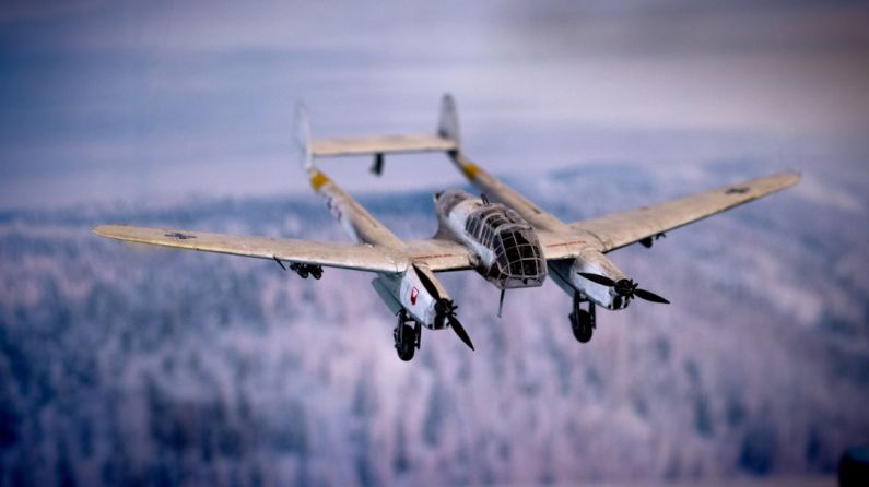 Historical Gear - a fighter jet flying through the air over a forest