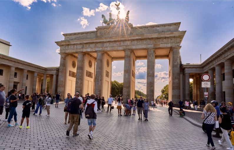 Diseases Horse - a large group of people walking around Brandenburg Gate with a statue on top