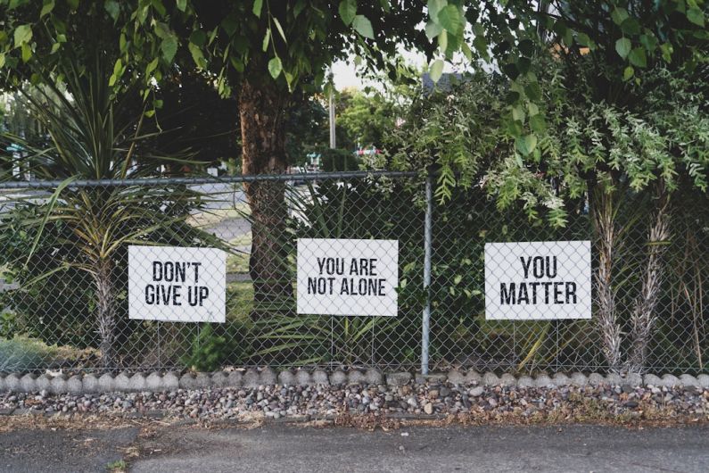 Mental Health - don't give up. You are not alone, you matter signage on metal fence