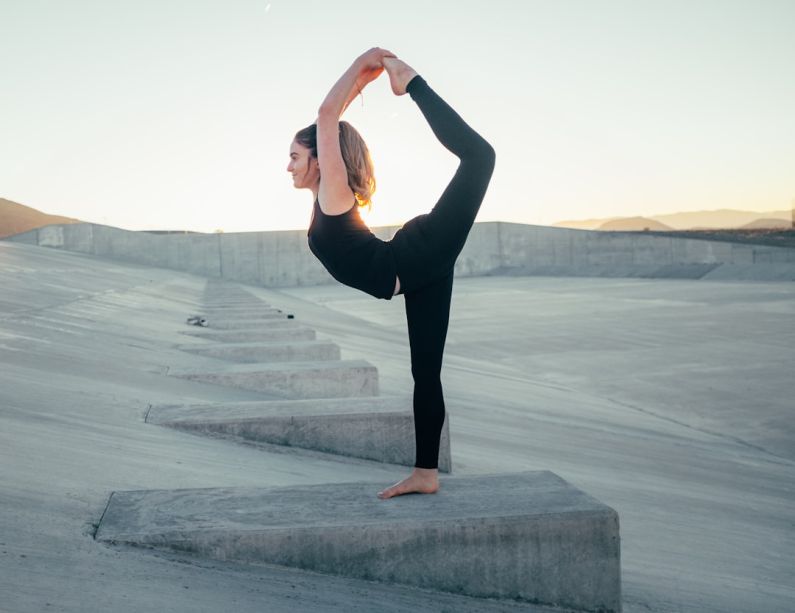 Flexibility Riding - shallow focus photo of woman in black sleeveless shirt doing yoga